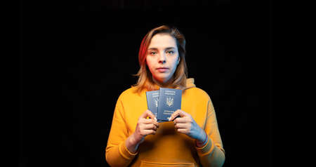 Ukraine national passport. Beautiful ukrainian girl with government passport in her hands on black...