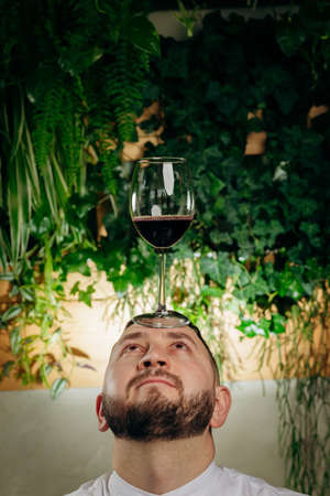 Professional chef and sommelier holding a glass of wine, wine culture conceptの写真素材