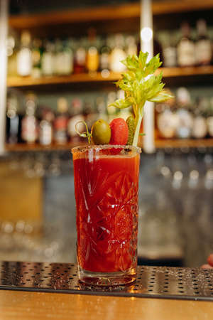 Bloody Mary cocktail with vodka, tomato juice and lemon, tabasco sauce and ice cubes decorated with celery leavesの写真素材