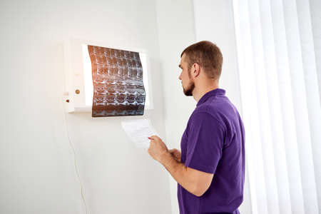The physiotherapist doctor examining X-ray or mri picture in private clinic. Surgeon or orthopedic...
