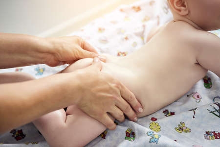 Massage therapist working with cute baby child in medical centerの写真素材