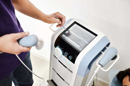 Radiofrequency therapy of the back. Physiotherapist doctor uses medical equipment for highly...