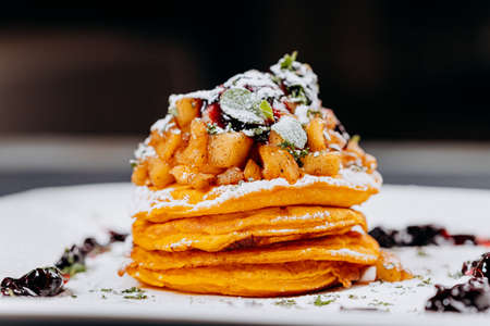 Delicious Pancakes are served with currant jam and apples on a plate ready for eatの写真素材
