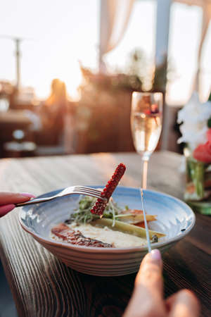 Close up of  woman eating delicious grilled octopus in seafood restaurant. Delicacy and healthy gourmet cuisineの写真素材