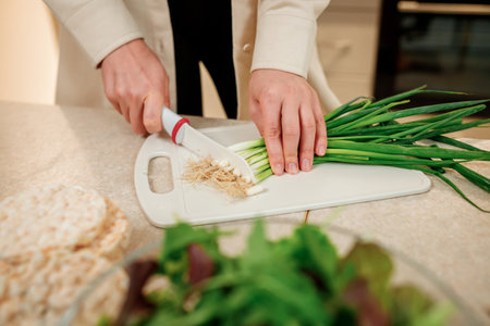 Close up of woman preparing vegetable vegan salad in the kitchen. Healthy food and diet concept lifestyle. Cook at homeの写真素材