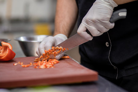Professional chef in uniform preparing fresh vegetables on cutting board in restaurant kitchen. Culinary conceptの写真素材