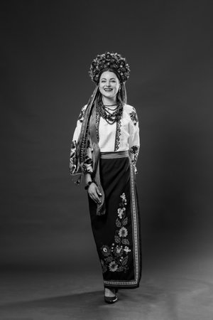 B/W Portrait of ukrainian woman in traditional ethnic clothing and floral red wreath on studio background. Ukrainian national embroidered dress call vyshyvanka. Pray for Ukraineの写真素材
