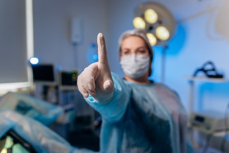 Female proctologist wearing medical uniform is posing showing fingers and smiling in hospital before operationの写真素材
