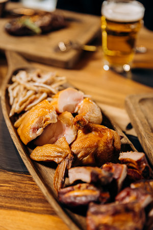 Beer appetizer. Smoked chicken fillet whole and sliced on wooden board. Rustic organic food, top viewの写真素材