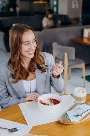 Young attractive woman enjoys tasty meal on cafe or restaurant backgroundの写真素材