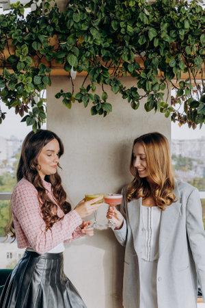 Attractive women are clinking and toasting with cocktails in restaurant or barの写真素材