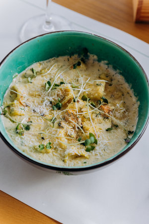 Tasty Mussels in cheese sauce with dumplings served with greens. Restaurant menu