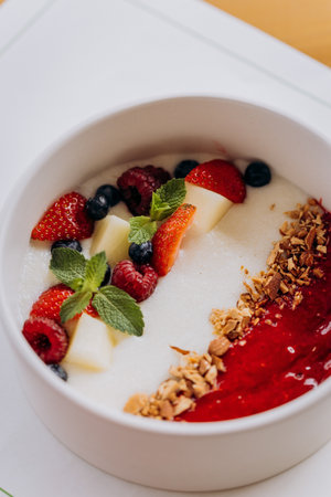Sweet milk semolina porridge with strawberries on beautiful plate. Delicious breakfast for childrenの写真素材