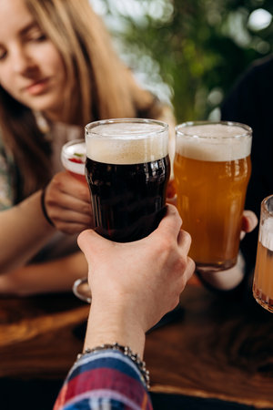 Friends toasting and drinking beer and cocktails in pub restaurant. Lifestyle party time conceptの写真素材