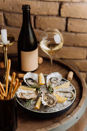 Fresh oysters on ice with lemon and wine, perfect for luxury dining experiences and celebrationsの写真素材