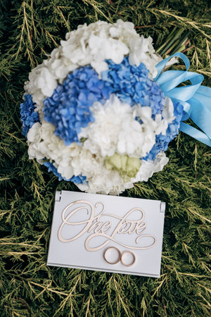 Elegant wedding details with floral bouquet and One Love sign, symbolizing eternal unity