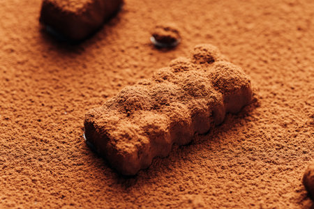 Close-up of chocolate truffle covered in cocoa powder, creating a rich and textured dessert sceneの写真素材