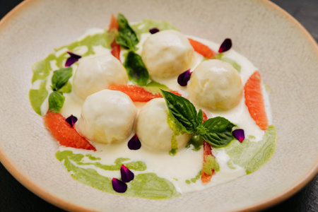 Gourmet cheese balls with herbs and citrus on an plate, perfect for culinary and food photographyの写真素材