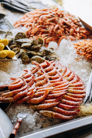 Fresh seafood assortment on ice at market. Shrimp, oysters, and corn for photography and menusの写真素材
