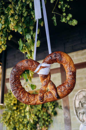 Traditional Bavarian pretzels displayed on stands with fresh hops, Oktoberfest and German cuisine