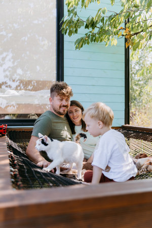 Family enjoying outdoor time with cat, creating precious moments of bonding and relaxation in nature