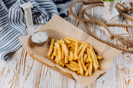 Golden French fries with a side of creamy dip, perfect for snack lovers