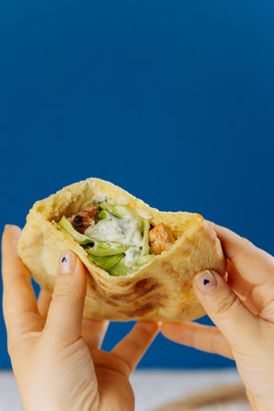Pita wrap filled with grilled chicken, lettuce, and creamy sauce, healthy fast food on the goの写真素材