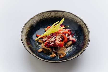 Stir fried vegetables and meat topped with sesame seeds, creating a vibrant and flavorful Asian dishの写真素材