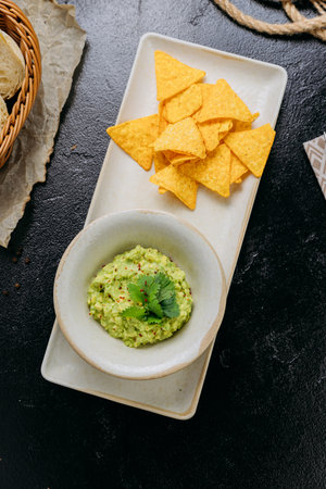 Classic guacamole with crispy tortilla chips, perfect for snacking or sharingの写真素材