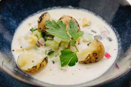 Chilled summer soup with fresh vegetables, potatoes, and creamy base, hot weather refreshmentの写真素材
