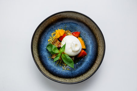 Fresh burrata with colorful tomatoes, basil, and pistachio crumbs. Gourmet appetizer perfection