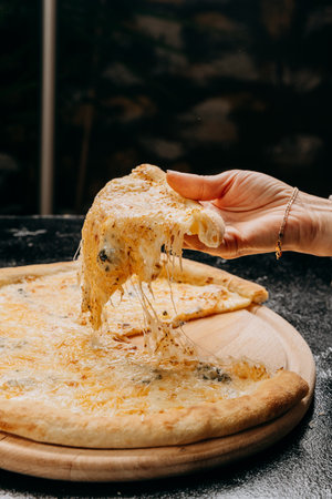 Melting cheesy pizza slice being lifted, showcasing gooey cheese pull, perfect for pizza loversの写真素材