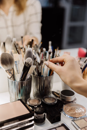 Hand selecting a makeup brush from a collection of beauty tools for a flawless application