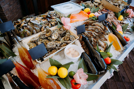 Seafood buffet display with oysters, shrimp, drinks, and fresh garnishes on ice for a gourmet feast