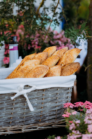 Freshly baked baguettes in a rustic basket, perfect for breakfast or dinner, surrounded by natureの写真素材