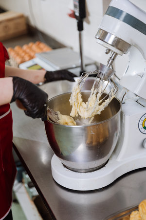 Mixing choux pastry dough in a professional mixer for baking in a commercial kitchen