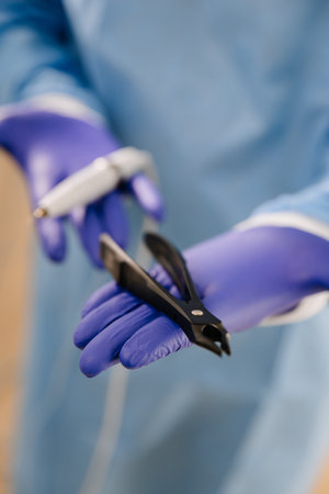 Dental tools held by a professional in sterile gloves, showcasing modern dentistry equipmentの写真素材