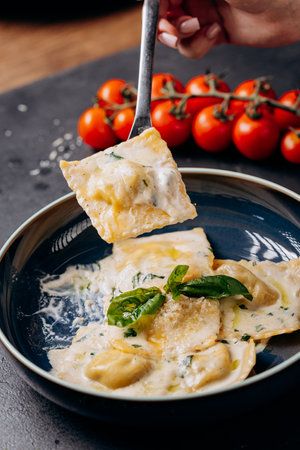 Fork lifting creamy basil ravioli, a perfect Italian gourmet dish for elegant food photographyの写真素材