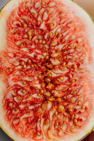 Close-up of a ripe fig revealing its intricate seed pattern and vibrant red interior