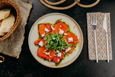 Roasted bell pepper carpaccio with arugula, feta cheese, pine nuts, and pesto, in gourmet styleの写真素材