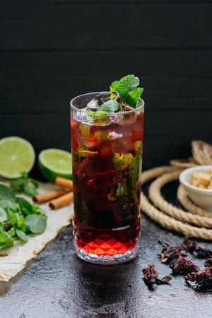 Refreshing hibiscus cocktail with lime, mint, and ice in a tall glass, summer and tropical vibesの写真素材