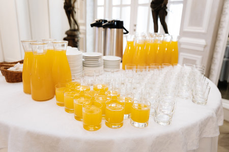 Glasses of orange juice served at elegant buffet table for event cateringの写真素材