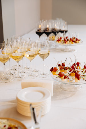 Elegant wine and appetizer setup on white table at upscale event or corporate receptionの写真素材