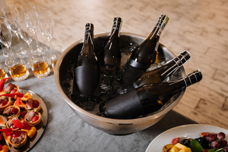 Chilled champagne bottles in ice bucket on elegant catering table at celebration eventの写真素材