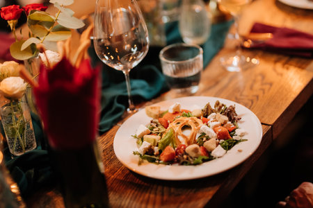 Fresh gourmet salad with goat cheese, croutons and watermelon at elegant dinner settingの写真素材