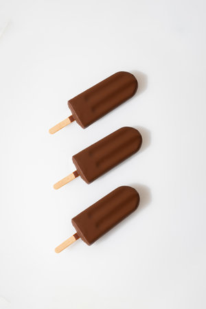 Chocolate ice cream popsicles on white background. Minimalist summer dessert conceptの写真素材