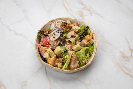 Traditional Georgian salad with vegetables, walnuts, and creamy dressing in ceramic bowlの写真素材