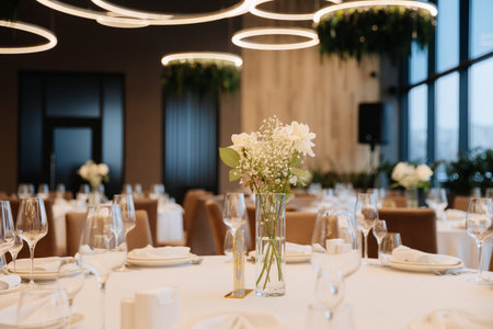 Elegant wedding table setup with white flowers and modern lighting in luxury restaurant