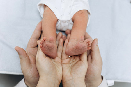 Newborn baby feet in parents hands symbolizing love, care and family protectionの写真素材