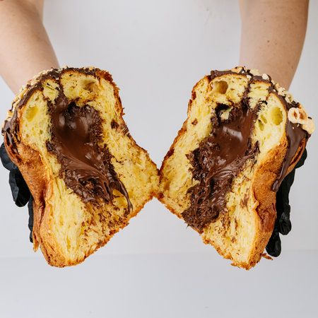 Hands in gloves holding sliced chocolate filled Christmas panettoneの写真素材